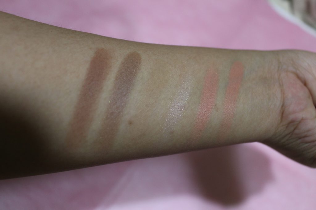 Left to Right: 1st shade on 1st row, a warm contour shade; 1st shade on 2nd row, a cool-toned contour shade; 2nd shade on 1st row, a bronzer shade; 2nd shade on 2nd row, a highlighter; 3rd shade on 2nd row, a pink blush; 3rd shade on 1st row, a coral blush with specks of glitter